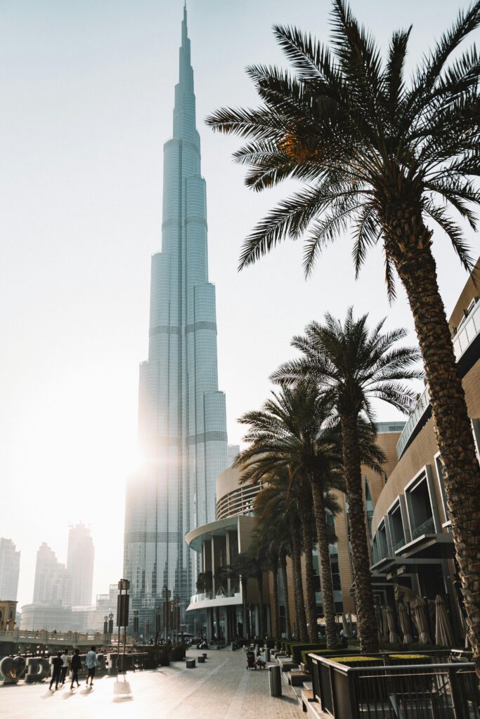 pexels photo 3243028 3243028 Sunlit view of Burj Khalifa surrounded by palm trees and modern architecture in Dubai.